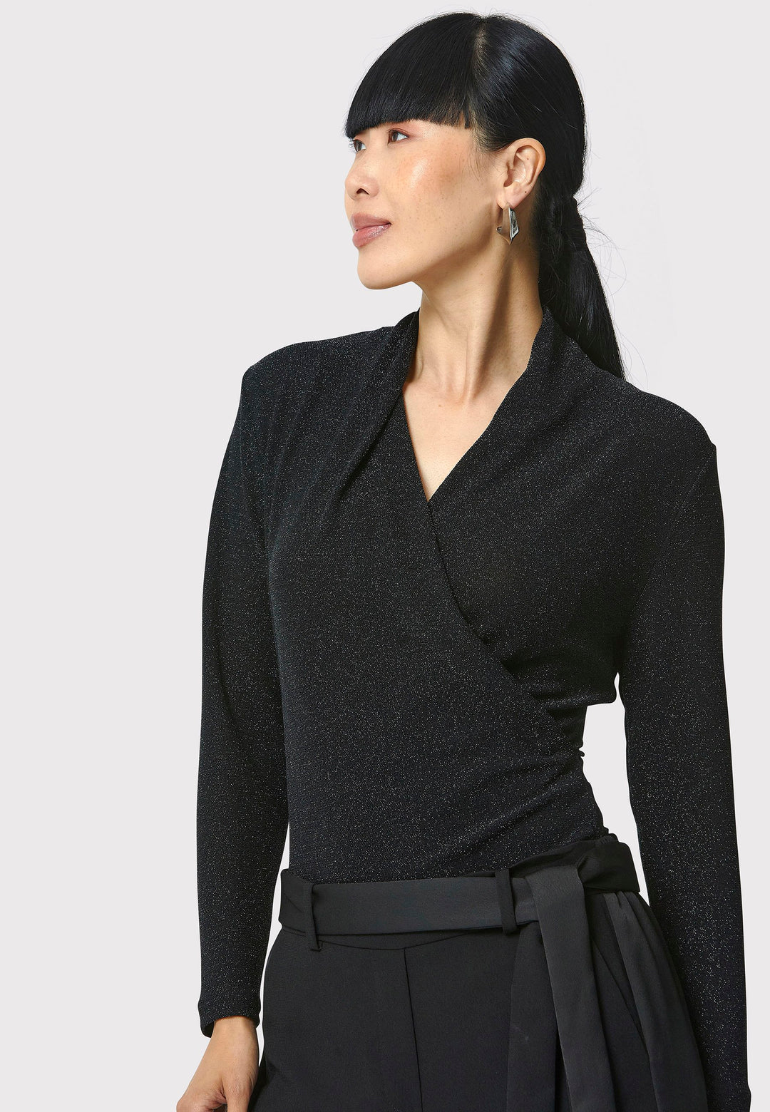 Introducing the Teagan Black Shimmer Top, a sophisticated boat neck blouse crafted from exquisite black jersey with a touch of glamour. This top effortlessly showcases timeless elegance and versatility, making it perfect for any occasion, whether a night out or a professional event.