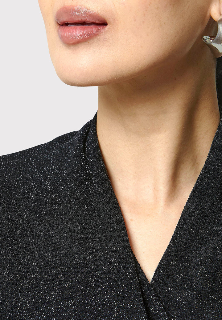 Introducing the Teagan Black Shimmer Top, a sophisticated boat neck blouse crafted from exquisite black jersey with a touch of glamour. This top effortlessly showcases timeless elegance and versatility, making it perfect for any occasion, whether a night out or a professional event.