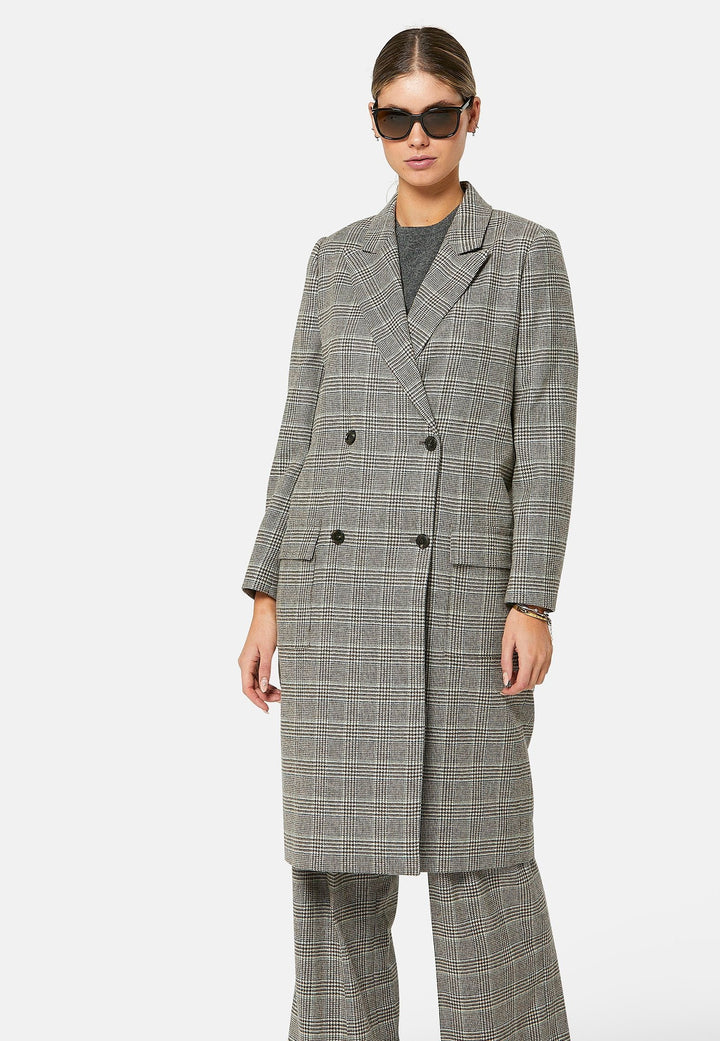 Introducing the Victoria Coat, a contemporary silhouette crafted in Magee lamsbwool. This double-breasted coat, featuring patch pockets and falls below the knee, it exudes timeless sophistication. The Victoria Coat elevates your transition and winter wardrobe.