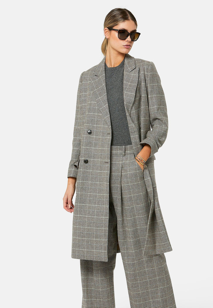 Introducing the Victoria Coat, a contemporary silhouette crafted in Magee lamsbwool. This double-breasted coat, featuring patch pockets and falls below the knee, it exudes timeless sophistication. The Victoria Coat elevates your transition and winter wardrobe.