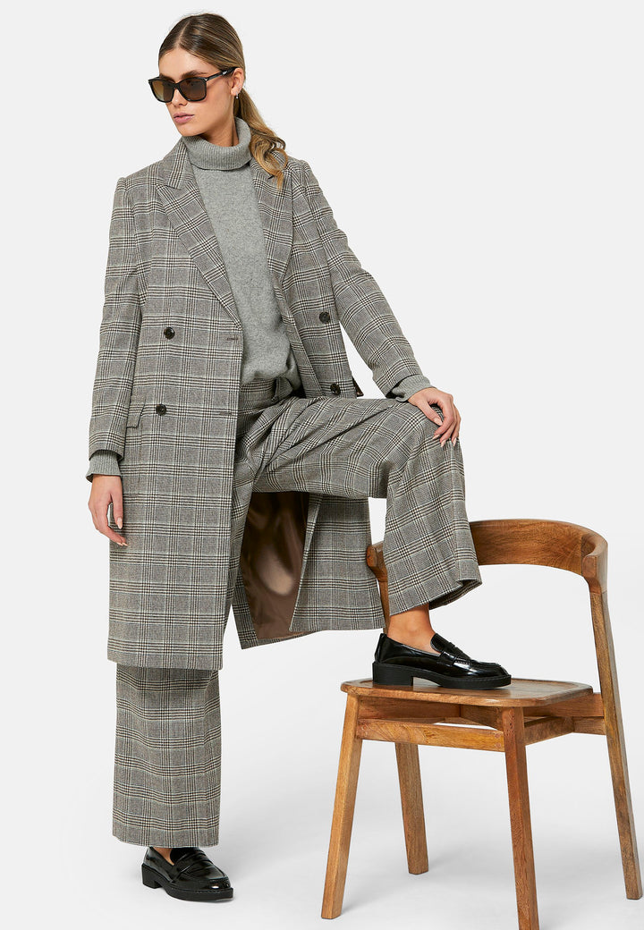 Introducing the Victoria Coat, a contemporary silhouette crafted in Magee lamsbwool. This double-breasted coat, featuring patch pockets and falls below the knee, it exudes timeless sophistication. The Victoria Coat elevates your transition and winter wardrobe.