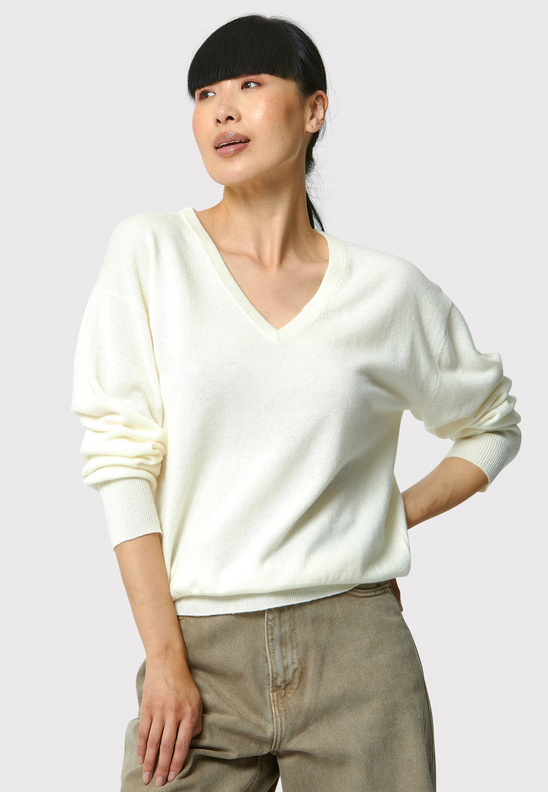 The Viv V-neck Cream Sweater is a luxurious blend of extra fine merino wool and cashmere, ensuring a soft and warm experience. 