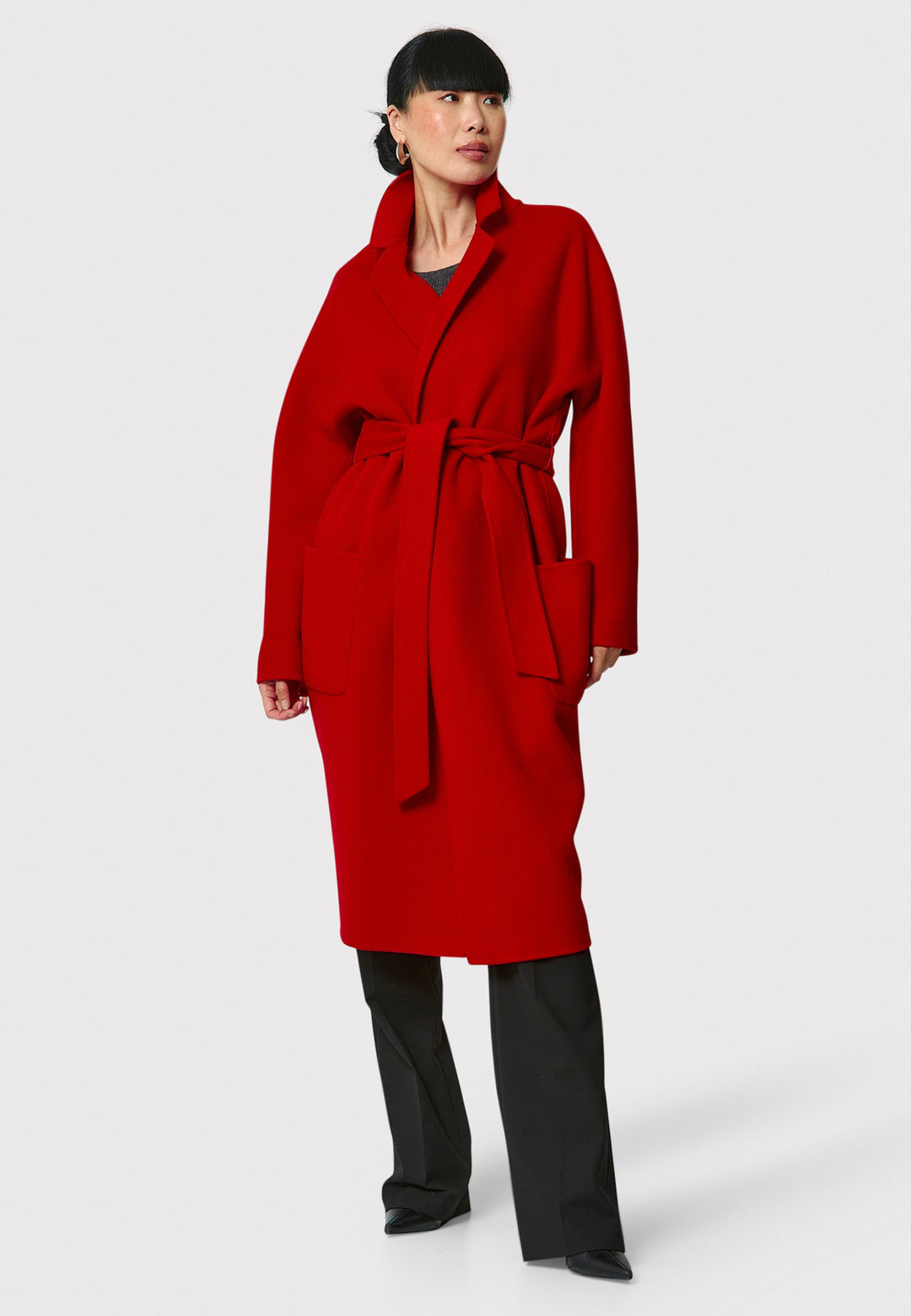 Introducing the Zola Cherry Red Cashmere Coat, a luxurious blend of cashmere and wool. This unlined coat features an oversized silhouette with patch pockets and a detachable belt. The dropped sleeves and tailor pick stitch finish add a touch of sophistication. Complete with a traditional collar and revere, it's a statement piece for your winter wardrobe.