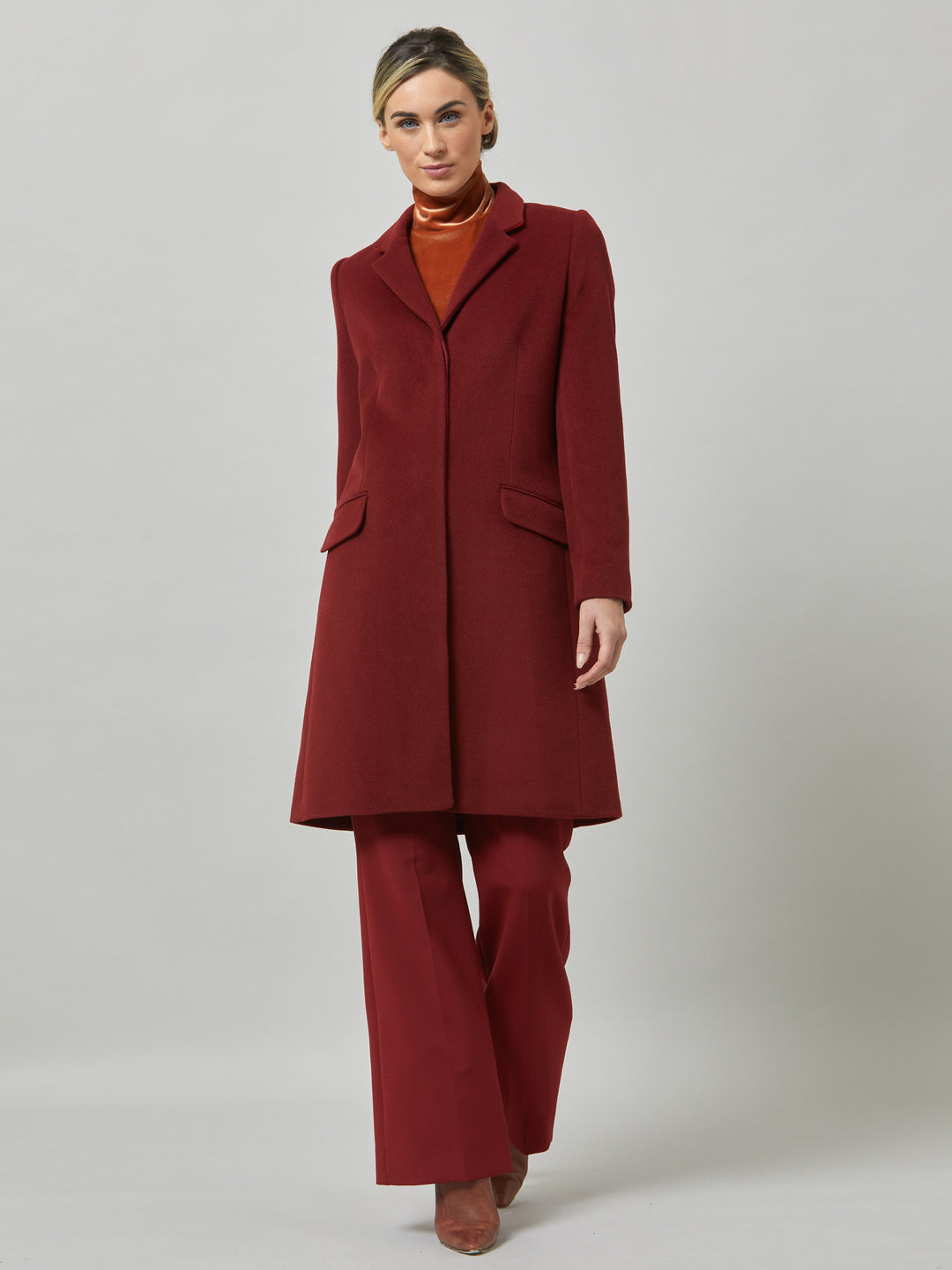 Lisa, practical winter glamour at its finest. Crafted in a warm russet red melton with a tidy collar & revere. Lisa features handy jeet pockets & concealed buttons. This knee-length coat ensures stylish winter warmth.