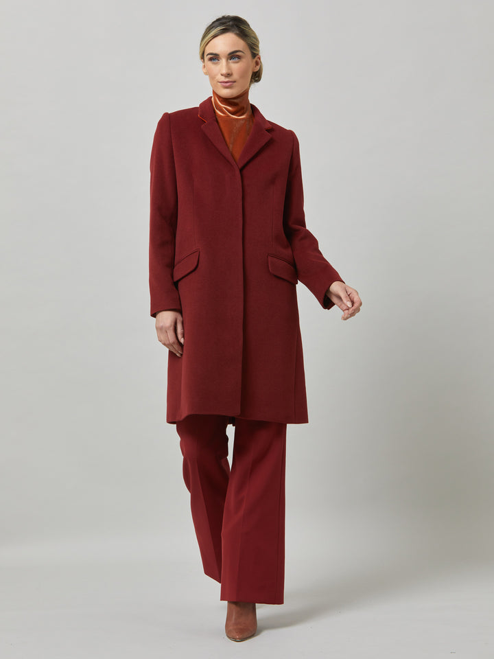 Lisa, practical winter glamour at its finest. Crafted in a warm russet red melton with a tidy collar & revere. Lisa features handy jeet pockets & concealed buttons. This knee-length coat ensures stylish winter warmth.