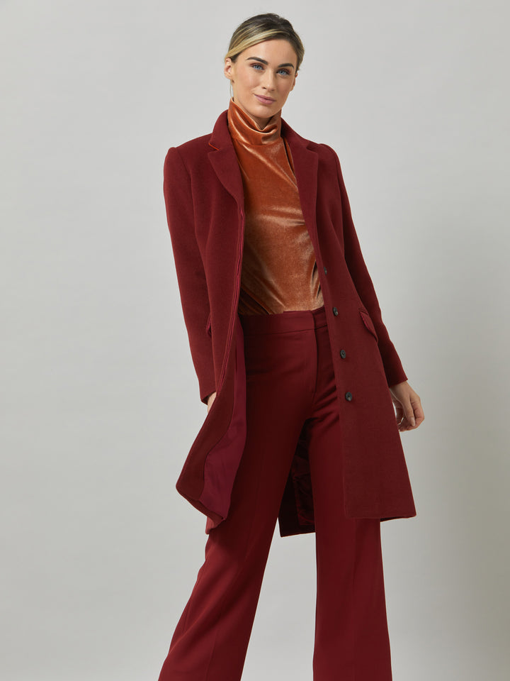 Lisa, practical winter glamour at its finest. Crafted in a warm russet red melton with a tidy collar & revere. Lisa features handy jeet pockets & concealed buttons. This knee-length coat ensures stylish winter warmth.